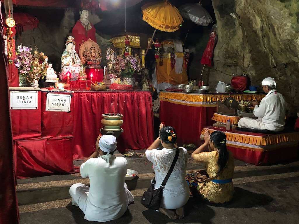 Worshippers inside the vast cavern of Goa Giri Putri Temple